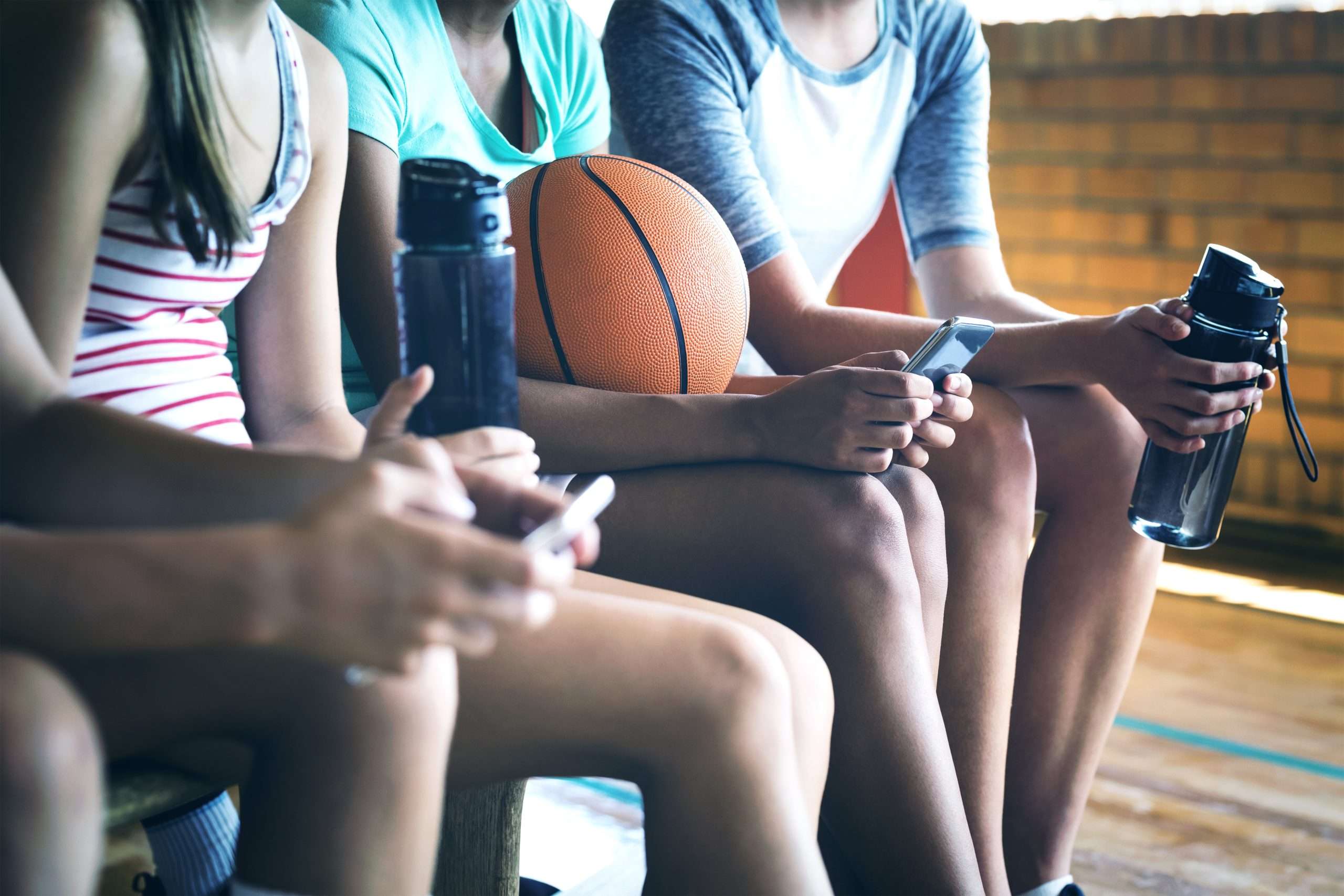 High school kids using mobile phone while relaxing in basketball court Larry Libertore University of Florida Football Quarterback